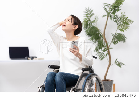 坐在輪椅上在家工作的婦女擔心 130843479