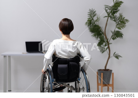 Woman in wheelchair, back view Woman in wheelchair, back view 130843501