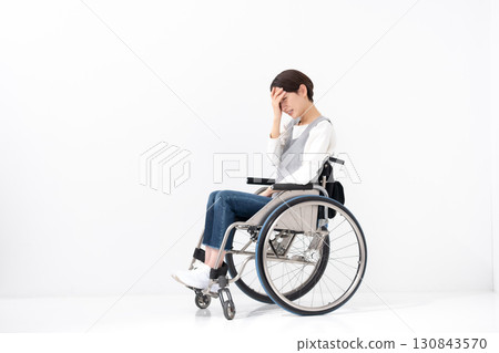 Worried woman in wheelchair, whole body Worried woman in wheelchair, whole body 130843570