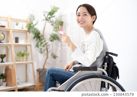 A woman in a wheelchair is happy to see her bankbook A woman in a wheelchair is happy to see her bankbook 130843579