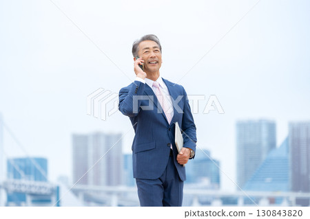 Businessman, buildings, smartphone Businessman, buildings, smartphone 130843820