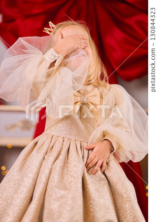 Shy Little Girl in a Gold Festive Dress 130844323