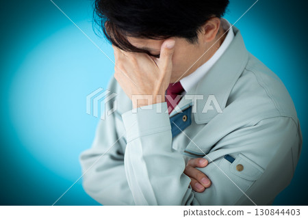 A middle-aged male businessman wearing work clothes who is worried A middle-aged male businessman wearing work clothes who is worried 130844403