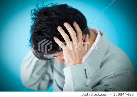 A middle-aged male businessman wearing work clothes who is worried A middle-aged male businessman wearing work clothes who is worried 130844486