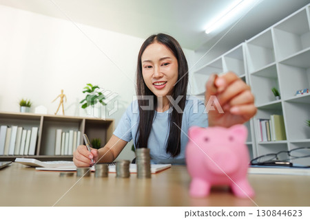 Financial Planning: Woman Writing and Saving Coins Financial Planning: Woman Writing and Saving Coins 130844623
