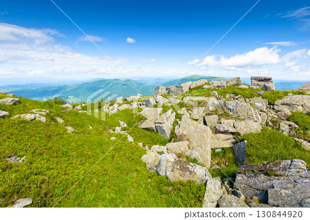 wonderful mountain landscape in summer. wide scenery with rock among grass on the hills and slopes under blue sky with fluffy clouds at high noon. scenic view of alpine environment wonderful mountain landscape in summer. wide scenery with rock among grass on the hills and slopes under blue sky with fluffy clouds at high noon. scenic view of alpine environment 130844920