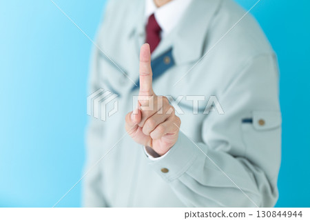 A middle-aged male businessman in work clothes pointing up his index finger 130844944