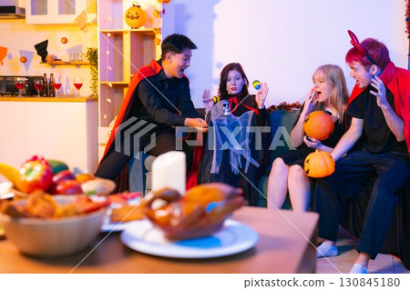 Dinner and group of people celebrating together at Halloween party. Dinner and group of people celebrating together at Halloween party. 130845180
