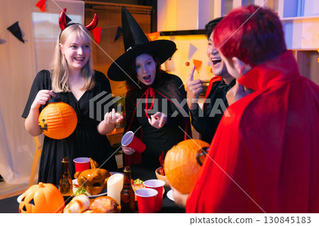 Dinner and group of people celebrating together at Halloween party. Dinner and group of people celebrating together at Halloween party. 130845183