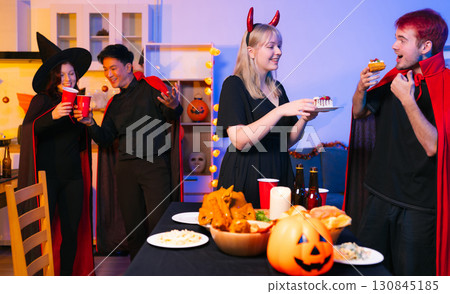 Dinner and group of people celebrating together at Halloween party. Dinner and group of people celebrating together at Halloween party. 130845185