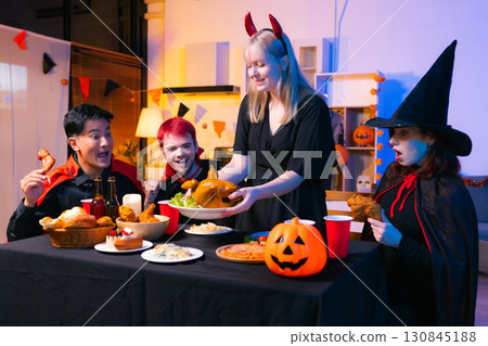 Dinner and group of people celebrating together at Halloween party. Dinner and group of people celebrating together at Halloween party. 130845188