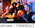 Dinner and group of people celebrating together at Halloween party. 130845212