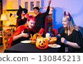 Dinner and group of people celebrating together at Halloween party. 130845213
