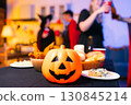 Dinner and group of people celebrating together at Halloween party. 130845214