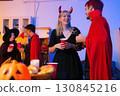 Dinner and group of people celebrating together at Halloween party. 130845216