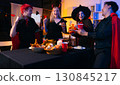 Dinner and group of people celebrating together at Halloween party. 130845217