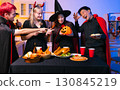 Dinner and group of people celebrating together at Halloween party. 130845219