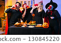 Dinner and group of people celebrating together at Halloween party. 130845220