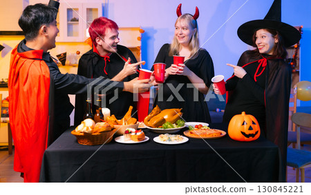 Dinner and group of people celebrating together at Halloween party. Dinner and group of people celebrating together at Halloween party. 130845221