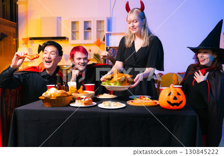 Dinner and group of people celebrating together at Halloween party. Dinner and group of people celebrating together at Halloween party. 130845222