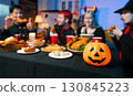 Dinner and group of people celebrating together at Halloween party. 130845223