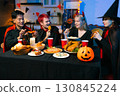 Dinner and group of people celebrating together at Halloween party. 130845224