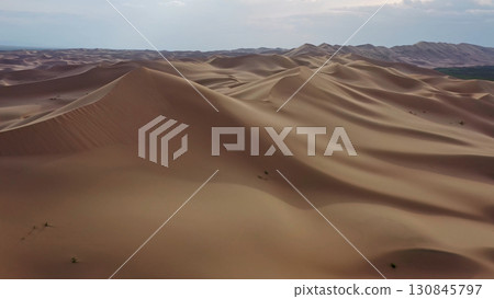 Aerial view of sand dunes in desert at sunset 130845797