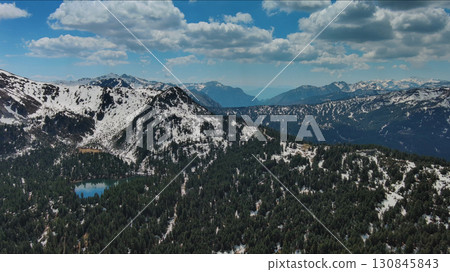 Rocky mountains in snow and green fir forest 130845843