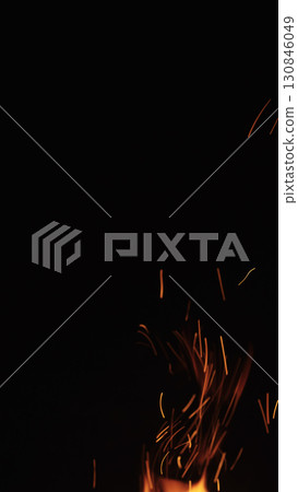 sparks and embers from campfire flying over black background 130846049