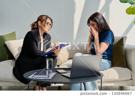 Sad unhappy woman in therapy session with female psychologist 130846067