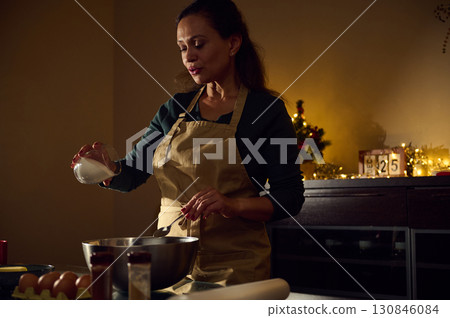 Woman Preparing Holiday Cookies in Festive Christmas Kitchen Setting 130846084