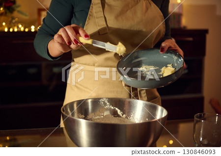 Woman Baking Holiday Cookies in Christmas-Themed Kitchen Environment Woman Baking Holiday Cookies in Christmas-Themed Kitchen Environment 130846093