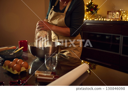 Woman Baking Gingerbread Cookies in Festive Kitchen with Christmas Decorations Woman Baking Gingerbread Cookies in Festive Kitchen with Christmas Decorations 130846098