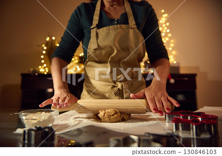 Chef Preparing Festive Holiday Gingerbread Cookies in a Christmas-Themed Kitchen Chef Preparing Festive Holiday Gingerbread Cookies in a Christmas-Themed Kitchen 130846103