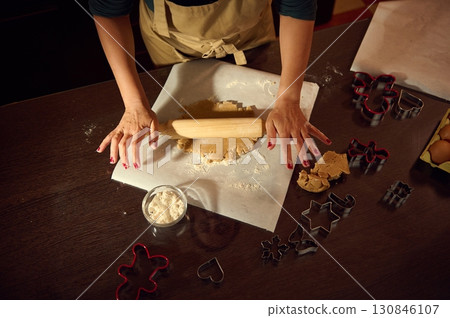 Woman Preparing Festive Gingerbread Cookies with Rolling Pin and Cutters Woman Preparing Festive Gingerbread Cookies with Rolling Pin and Cutters 130846107