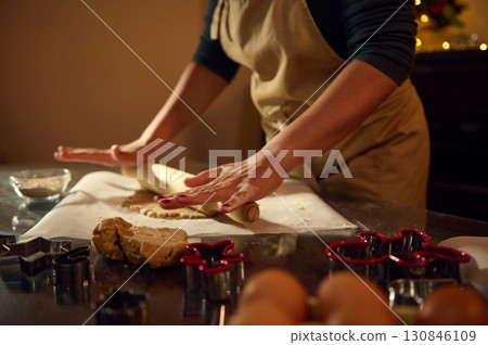Woman Making Holiday Gingerbread Cookies in a Warm Festive Kitchen Woman Making Holiday Gingerbread Cookies in a Warm Festive Kitchen 130846109