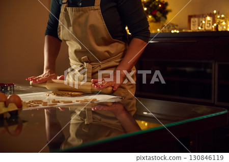 Woman Baking Gingerbread Cookies in a Warm Christmas Kitchen Setting 130846119