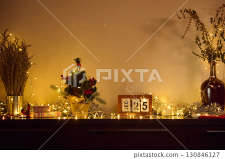 Festive Arrangement with Lights and Christmas Decorations on a Dresser Festive Arrangement with Lights and Christmas Decorations on a Dresser 130846127
