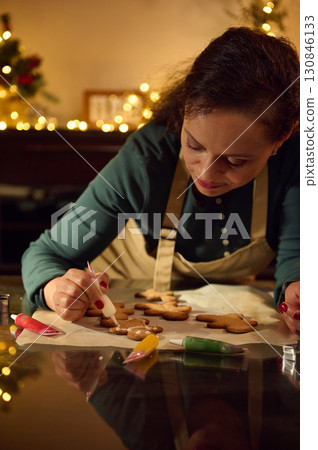 Woman Decorating Gingerbread Cookies in Festive Christmas Atmosphere 130846133