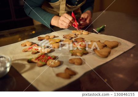 Woman Decorating Gingerbread Cookies for the Festive Christmas Holiday Season 130846155
