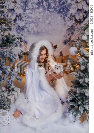 A girl in a winter wonderland with a fluffy owl A girl in a winter wonderland with a fluffy owl 130846502