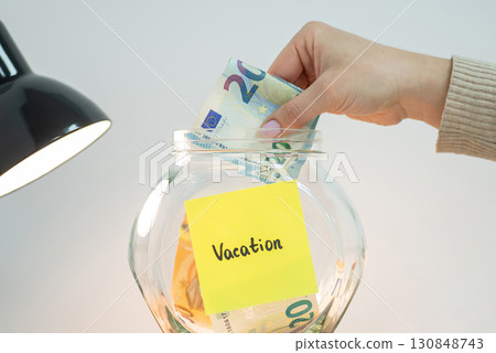 Putting euro money to bank with inscription Vacation. Saving up for travel, trip, holidays, vacation concept Putting euro money to bank with inscription Vacation. Saving up for travel, trip, holidays, vacation concept 130848743