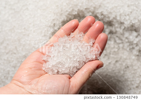 Close up of hail in hands after hailstorm. Big amount of hail on the ground Close up of hail in hands after hailstorm. Big amount of hail on the ground 130848749