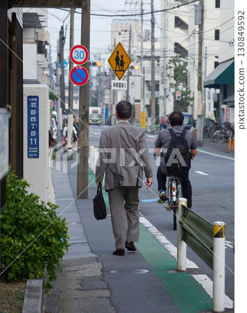夏季城市街道上步行上班的男辦公室職員 夏季城市街道上步行上班的男辦公室職員 130849592