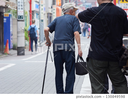 Senior man walking in a shopping street in a city in summer Senior man walking in a shopping street in a city in summer 130849598