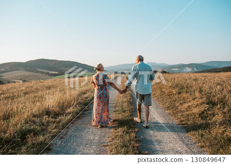 Senior couple on walk during sunset. 130849647