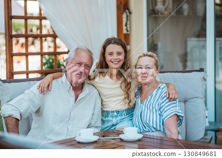 Smiling elderly couple enjoying coffee together in the garden. 130849681