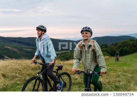 Family riding bicycles in mountains. Cycling trip during autumn day. 130849734