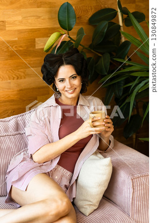 Portrait of woman with hair rollers during slow morning. 130849872