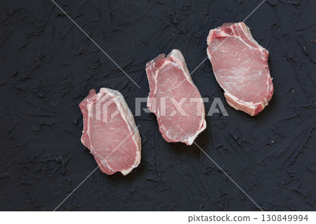 Raw Pork Chops with Spices and Herbs on Dark Rustic Background 130849994